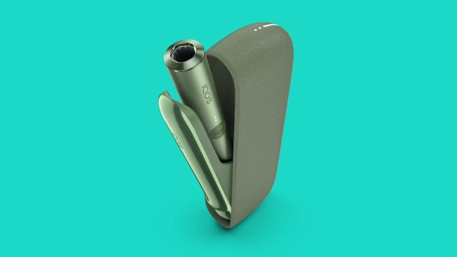 IQOS ILUMA Green Moss krāsā un tirkīza fonā.